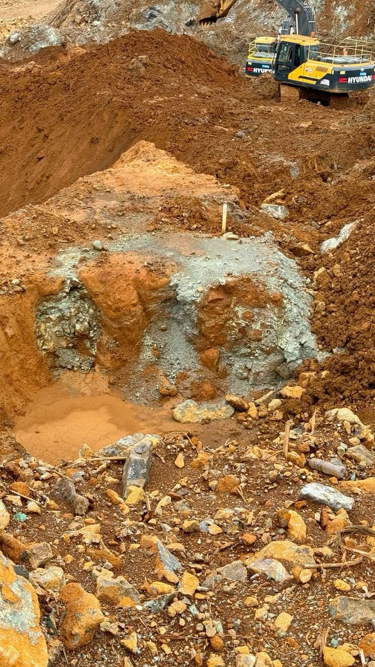 Excavator working an active open-pit mine face