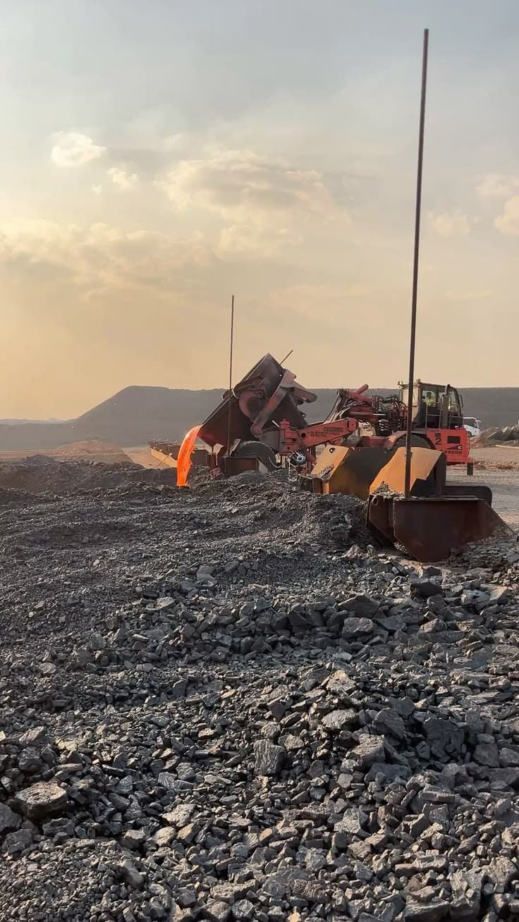 Mining equipment processing ore at an active site at golden hour